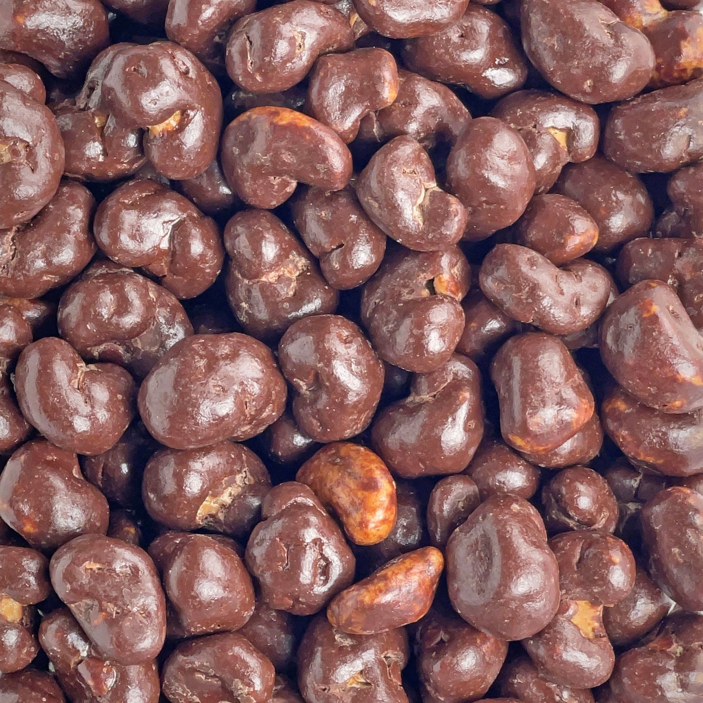 Viele Schokolierte Nüsse auf einem Haufen. Glänzende Schokolade vom Chocolatier.